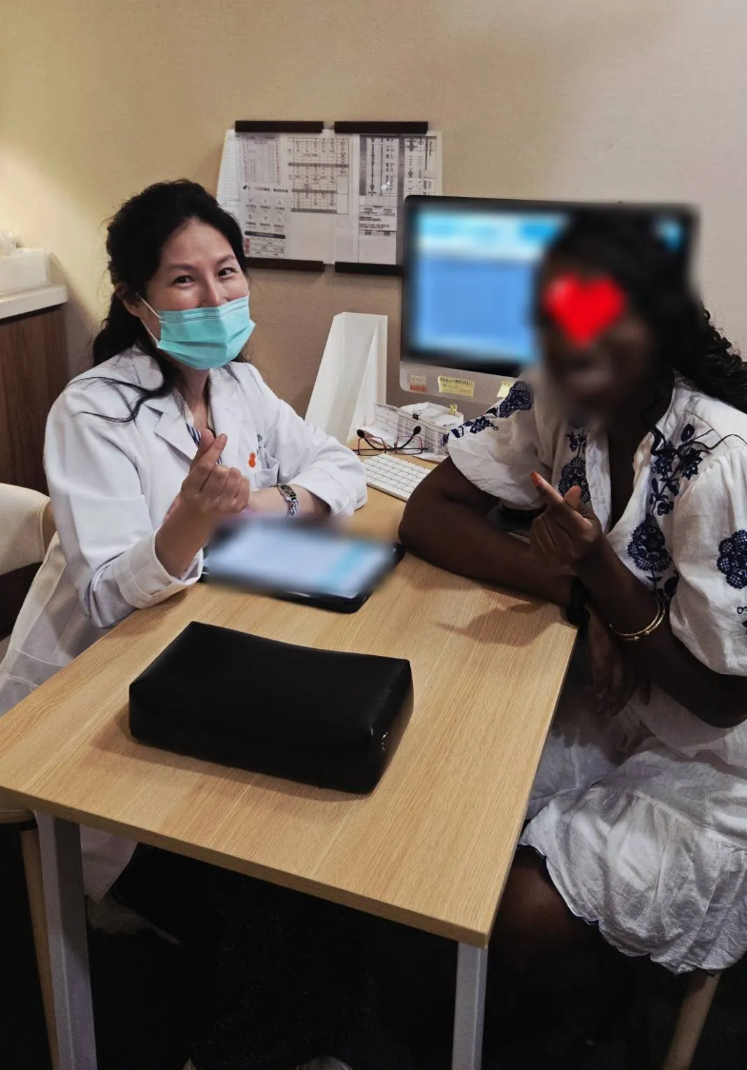 診間合影。照片已去識別化處理：臉部與電腦螢幕畫面均經處理